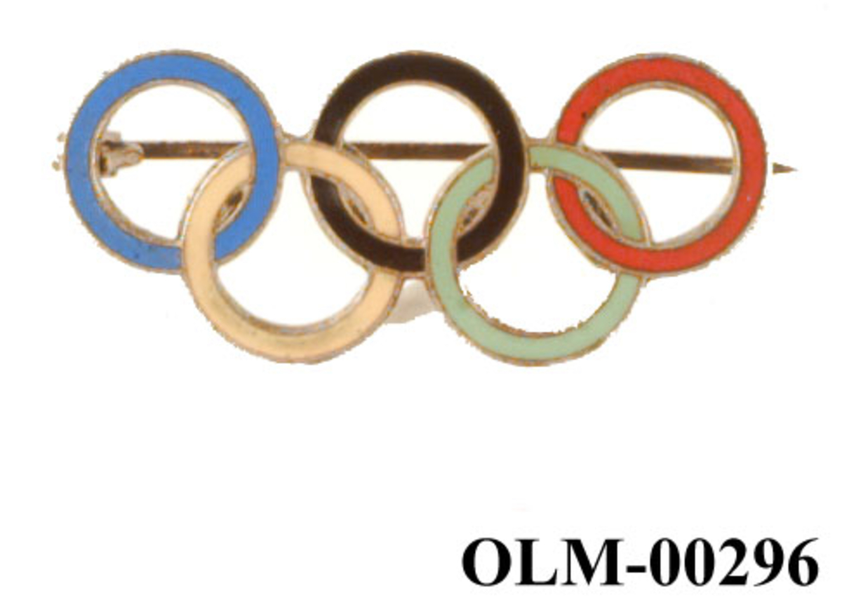 Merke av metall med motiv av og form som de olympiske ringene. Ringene er i farger.