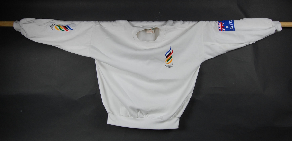 Hvit genser med logo for kandidatbyen Melbourne i forbindelse med søkeprosessen til de olympisker i 1996. Det Australske flagget er påsydd på venstre erme.