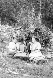 Gruppe på fire kvinner sitter igresset. Nevnt som gruppen ti