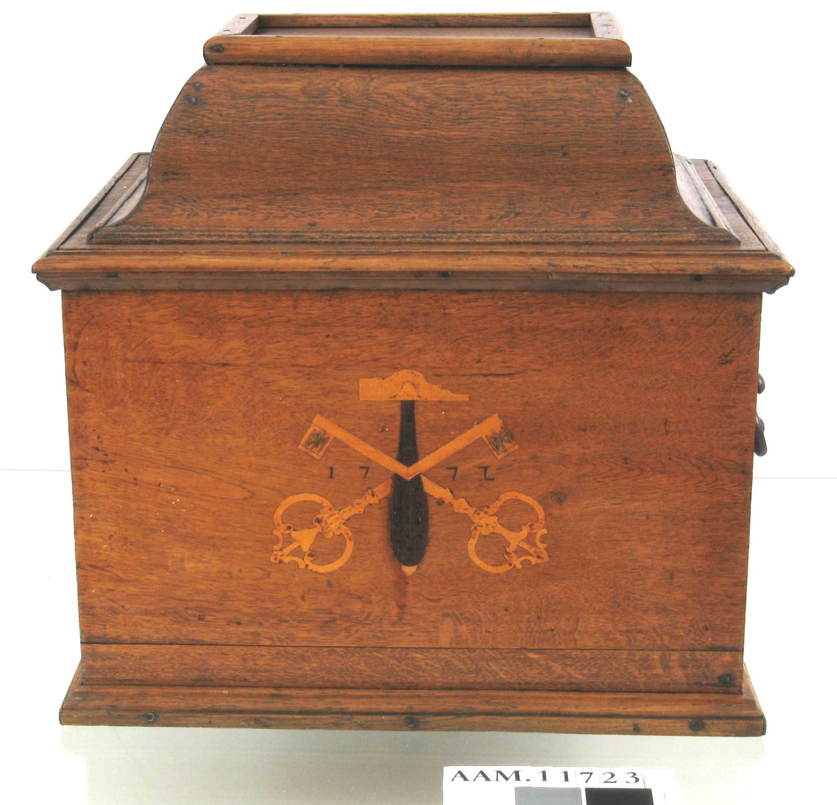 På skrinets forside en hammer med to korslagte nøkler i intarsia og  årstallet 1772.