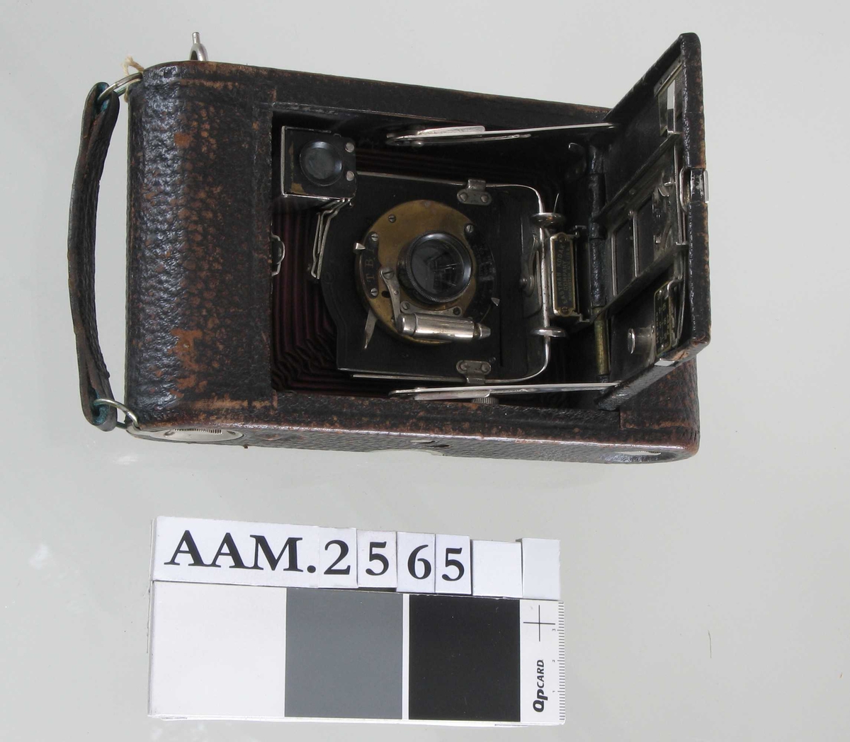 Fotoapparat i etui  "Telma", Zeiss Ikon Datering: 1930-årene a)Apparat, sort  bakelitt,  forkrommete ståldeler/skruer  H. med sikte 8,5 L.13,5 Dybde 4,3  Smal rektangulær hovedform med avfasede hjørner. Foldeapparat, linsen merket  Zeiss Ikon Telma.  Nettar, Anastigmat. 1:6,3 F = 7,5cm. Innvendig etikett:  Zeiss Ikon Film, med filmeske i farger. b) Skinnpose, sort, med glidelås i den ene kortende. L.ca.20 B.Ca. 10,5 
