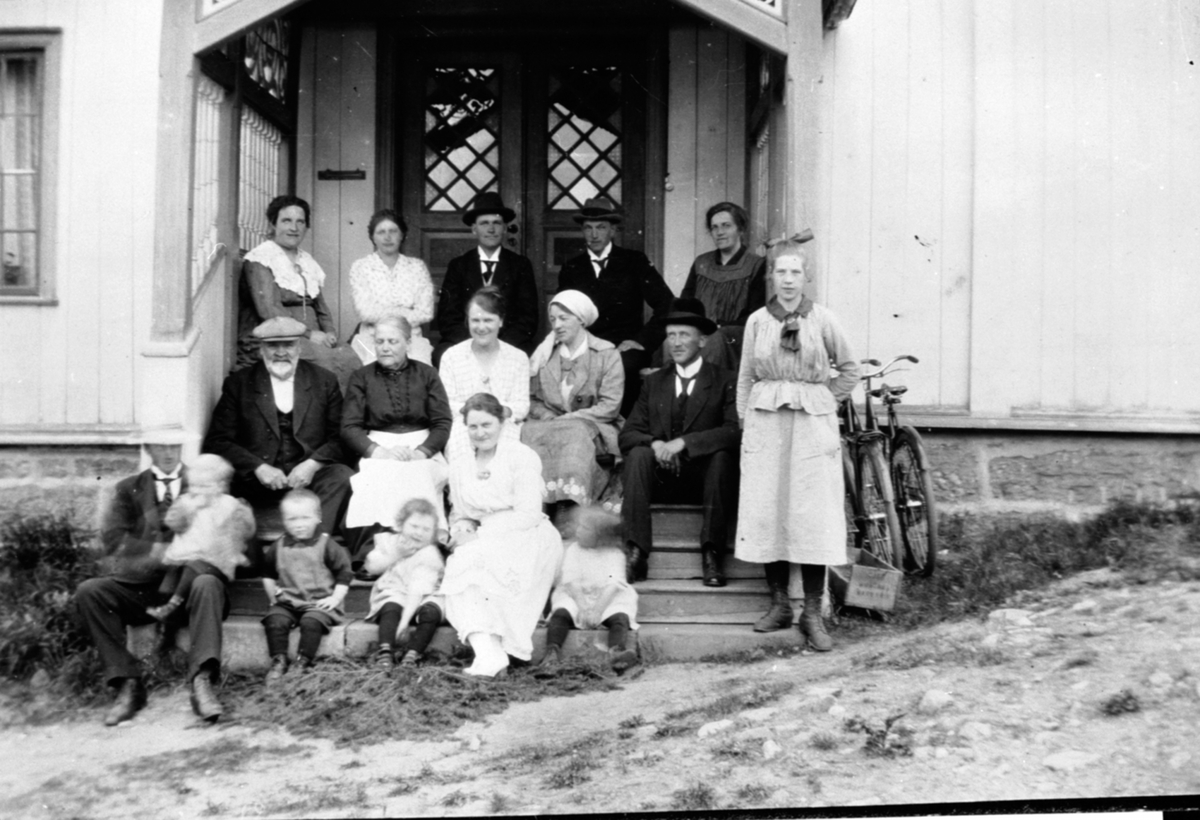 Voksne og barn foran inngang på øvre bygning, Simenstad, Veldre, Ringsaker. Ansten Haakensen Simenstad f.1852 og Dina Ingeborg Simenstad f.1861 med barn, svigerbarn og barnebarn.