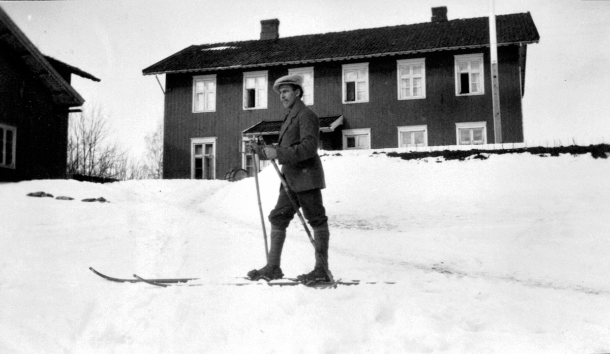 Kristian Olesen med ski utenfor hovedbygningen på Berg østre, Ringsaker.