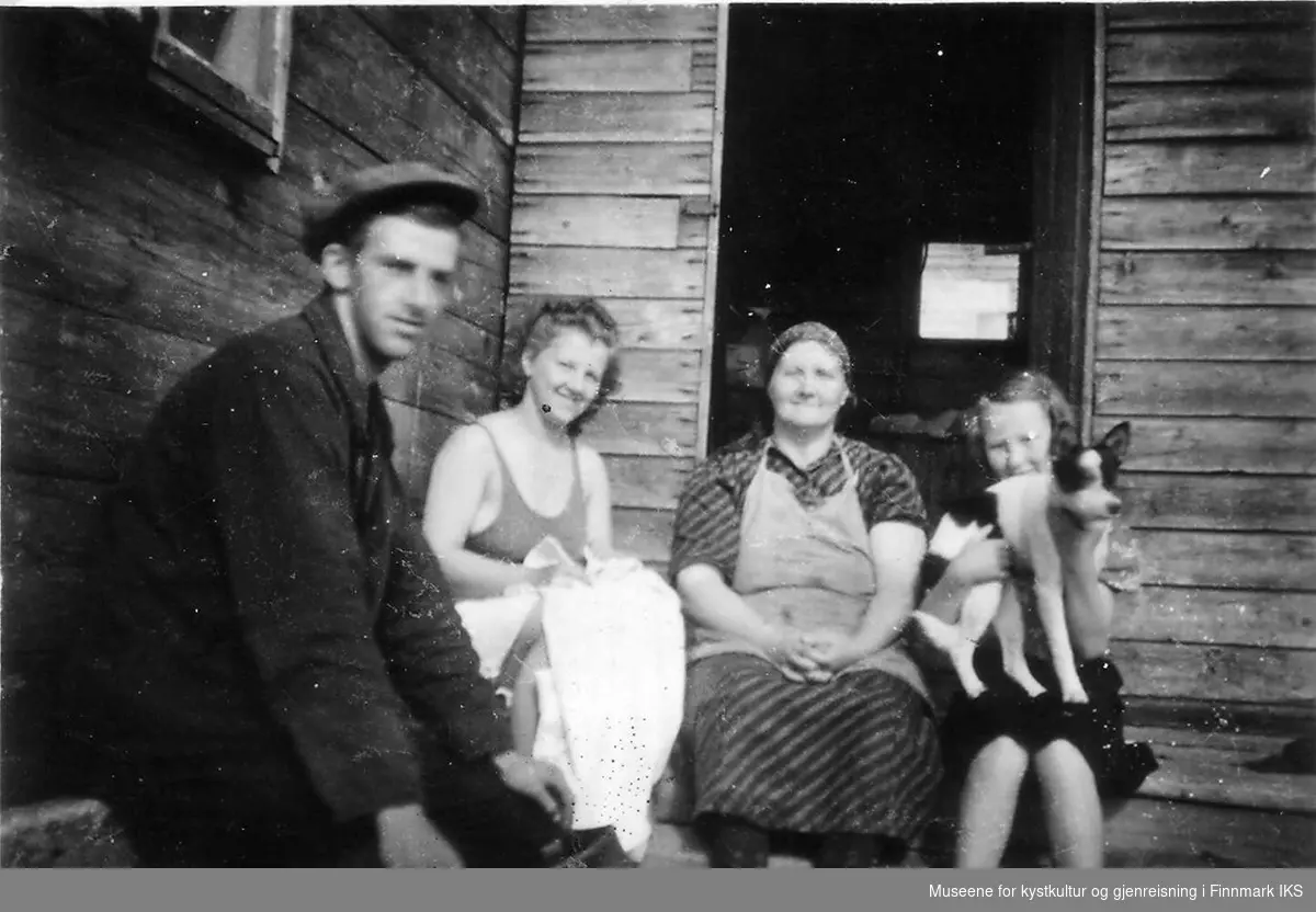 Fra venstre: Arne Olsen, Randi, Hilda og Ingrid Andersen, sitter utfor et hus i Kongsfjord, ca 1947