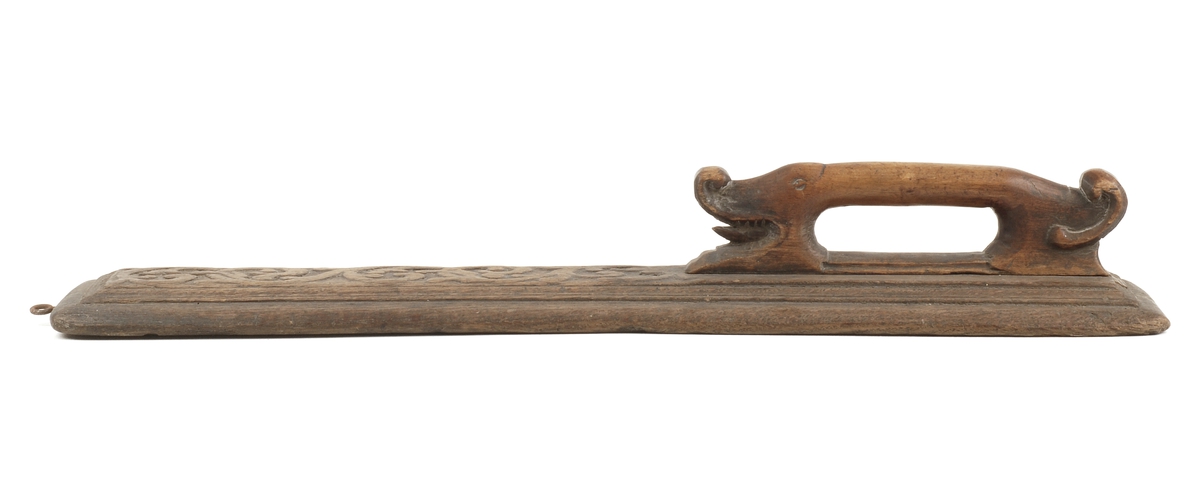 Mangletreets håndtak er utformet som et dyr en drage / bøyle form.
Håndtakssidens overside er dekorert med en utskåret rankedekor i relieff.