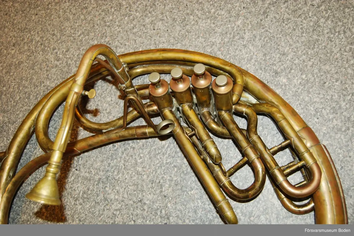 Äldre sousafon (bastuba för marscherande musiker) av mässing. Ingen märkning kan hittas. Har sannolikt använts vid musikkår i Boden.