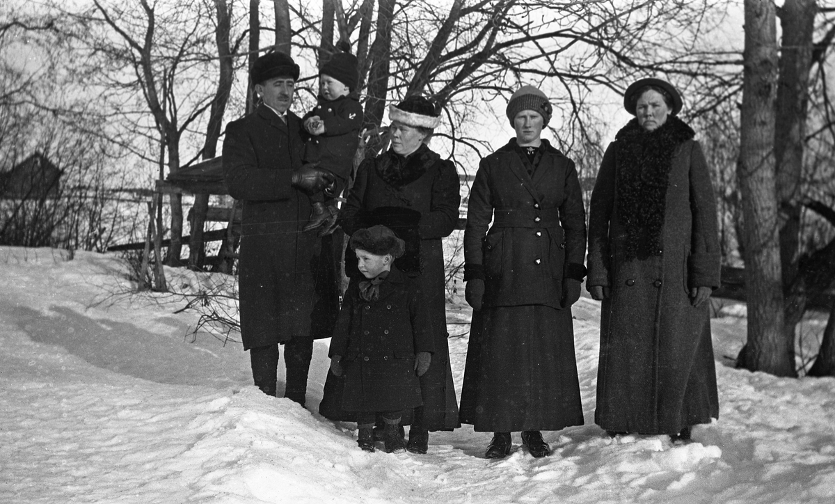 Nils og Anna Gunnerød med sine to eldste barn, Kåre stående, Leif på armen til Nils. Til høyre to uidentifiserte kvinner. Ca. 1917.