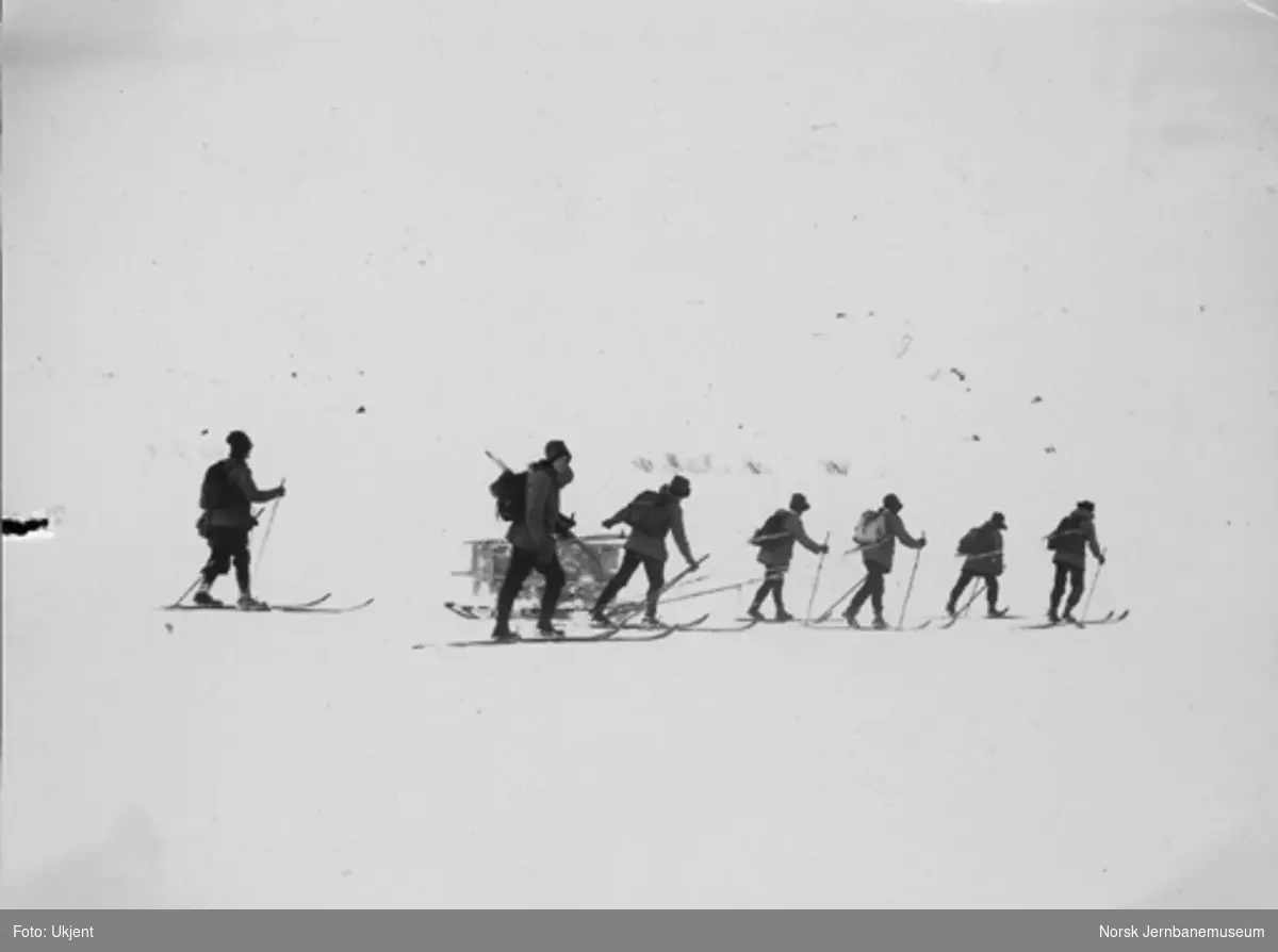 Snøblokade; sju mann på ski med utstyr