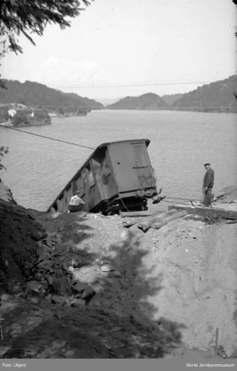 Togavsporing etter ras ved Kjose : avsporet personvogn litra CFo nr. 214, taket av kjølevognen i vannkanten