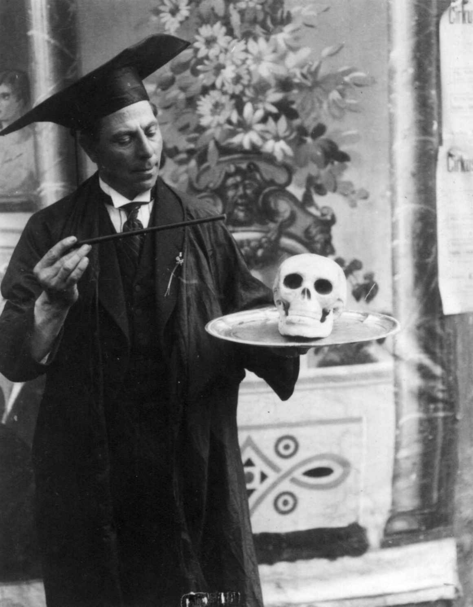 Mann med hodeskalle på et fat, antakelig tryllekunstner. Underholdning på marked på Norsk Folkemuseum i 1924.