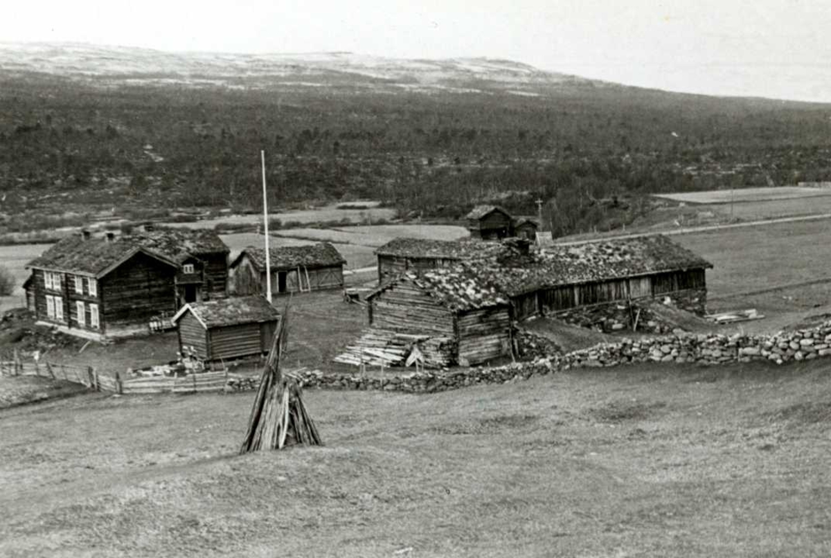 Synvisgård, Narjordet, Os, Nord-Østerdal, Hedmark. Gårdstunet med våningshus og uthus, sett fra et jorde på oversiden.