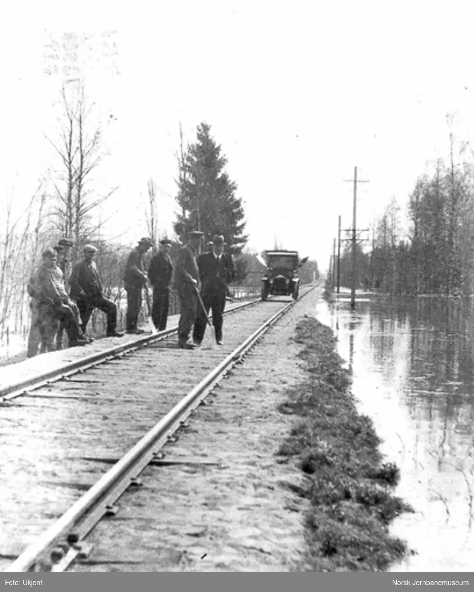 Banemannskaper og folk fra Hamar distrikt ved befaring på Rørosbanen ved flommen i 1934; distriktets inspeksjonsbil i bakgrunnen