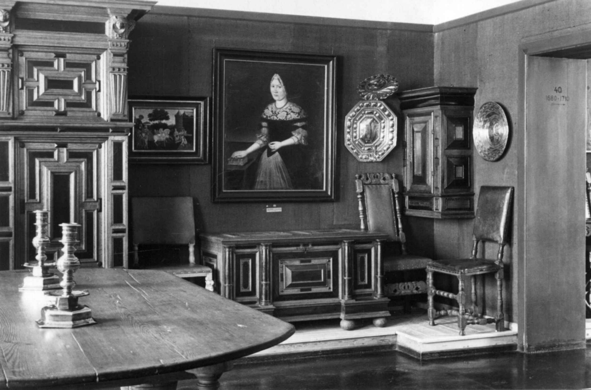 Interiør fra barokkrom slik som utstilt i Bysamlingen på Norsk Folkemuseum i 1936. Motivet viser forgylte møbler rundt et portrett på veggen.
