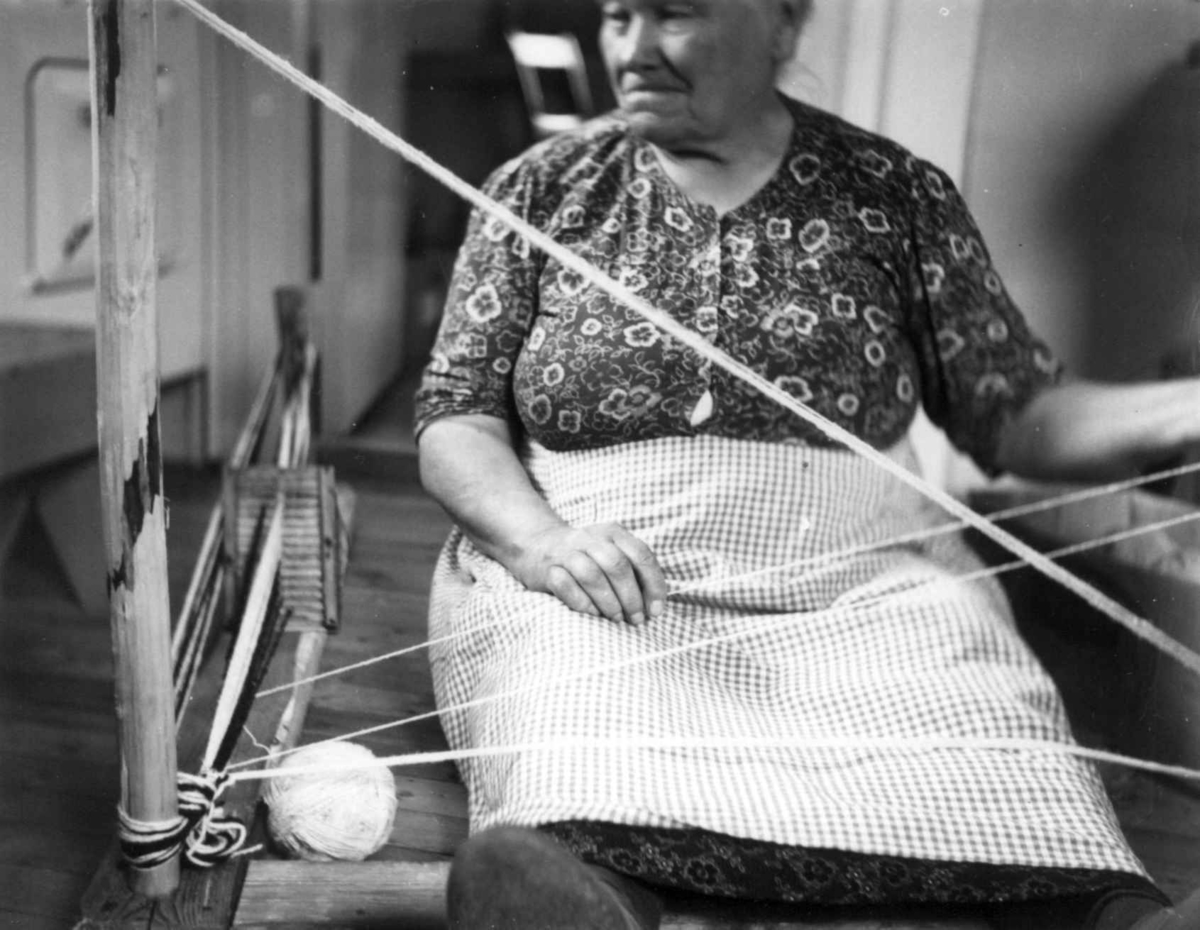 Greneveving (5). Anne Hansen begynner å veve båndet til greneteppet og varpe. Manndalen 1955.