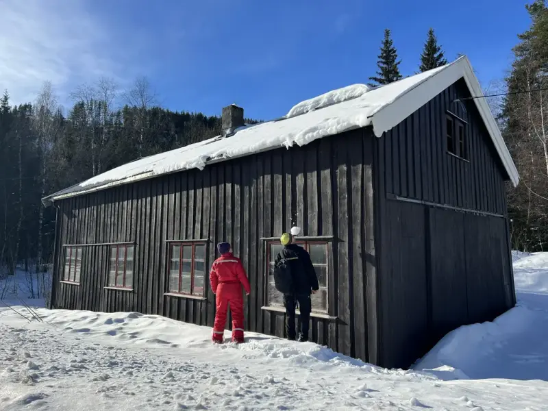 To personar som ser på eit gamalt hus